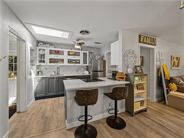 131 Oak Park Ave, Brooksville, FL 34601 - kitchen with a sink, light wood-type flooring, visible vents, freestanding refrigerator, and a skylight