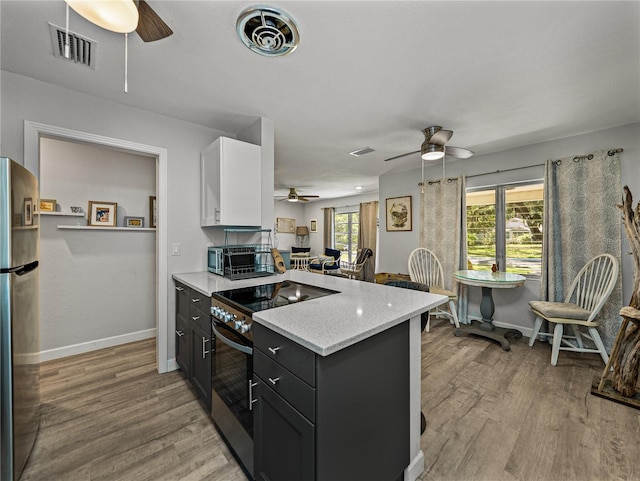 131 Oak Park Ave, Brooksville, FL 34601 - kitchen featuring ceiling fan, a peninsula, stainless steel appliances, and visible vents