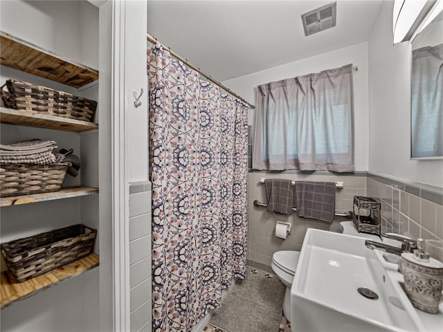131 Oak Park Ave, Brooksville, FL 34601 - full bath featuring visible vents, toilet, a shower with curtain, a sink, and tile walls