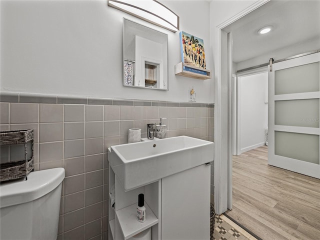 131 Oak Park Ave, Brooksville, FL 34601 - bathroom with a sink, toilet, tile walls, wainscoting, and wood finished floors