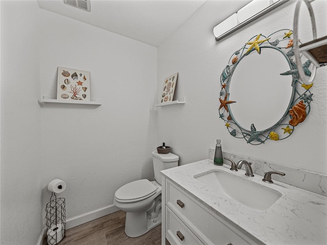 131 Oak Park Ave, Brooksville, FL 34601 - bathroom with wood finished floors, visible vents, toilet, vanity, and baseboards