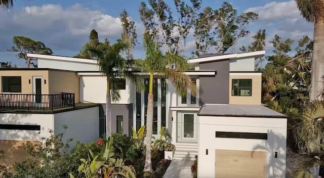 rear view of property with stucco siding and an attached garage