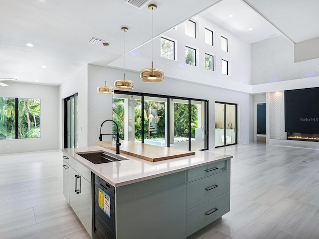 kitchen featuring an island with sink, visible vents, modern cabinets, a sink, and open floor plan