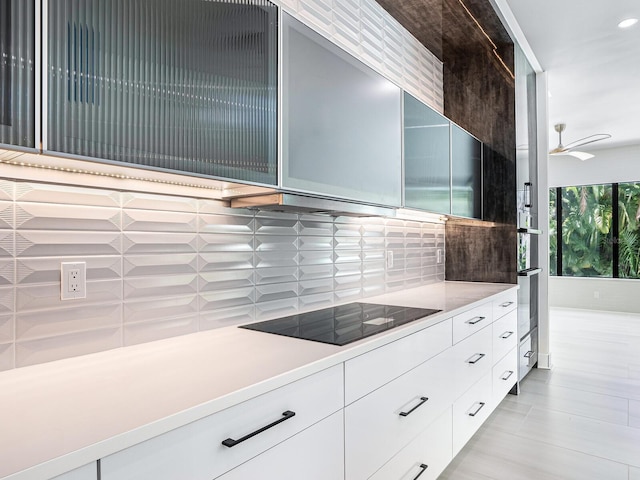 kitchen featuring backsplash, black electric cooktop, light countertops, and modern cabinets