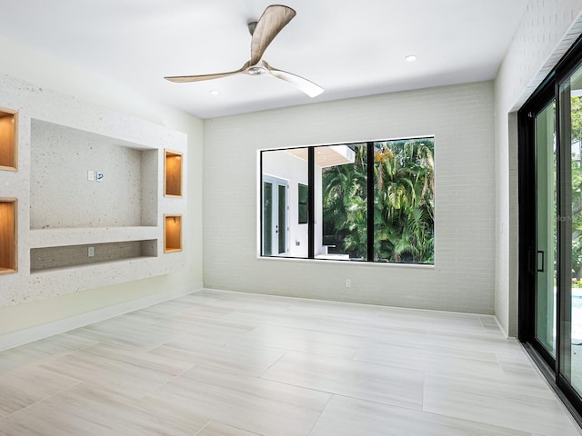 spare room with brick wall, a ceiling fan, tile patterned flooring, and recessed lighting