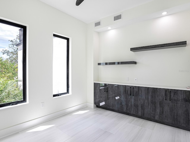 unfurnished room with visible vents, baseboards, and a healthy amount of sunlight
