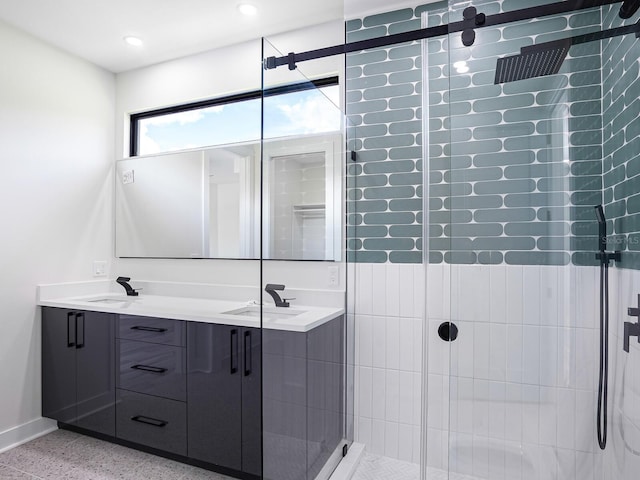 full bath with speckled floor, double vanity, a shower stall, and a sink