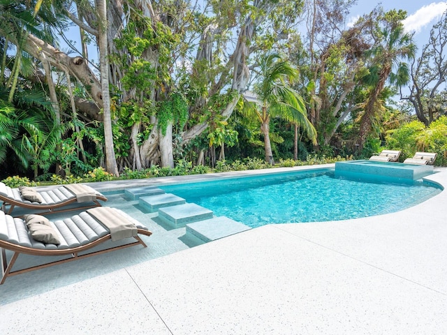 view of pool with a patio and a pool with connected hot tub