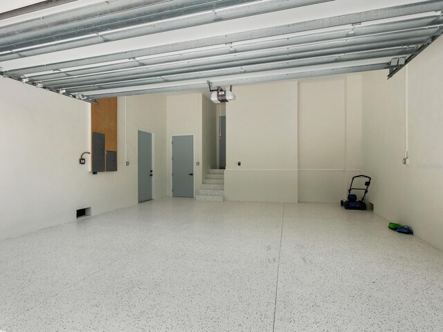 garage with electric panel and a garage door opener