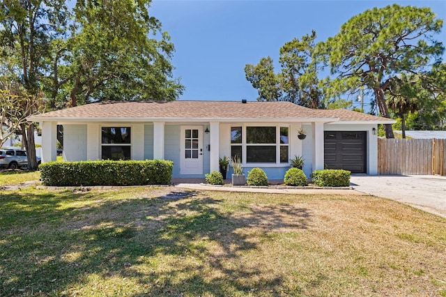 single story home with a front lawn, driveway, a shingled roof, fence, and a garage