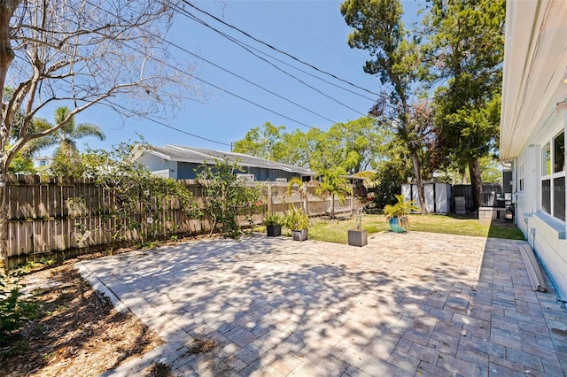 view of patio featuring a fenced backyard, an outbuilding, and a shed