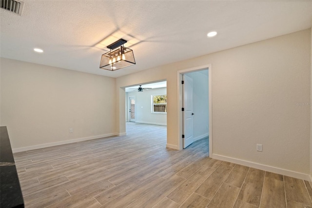 empty room with recessed lighting, visible vents, light wood-type flooring, baseboards, and ceiling fan
