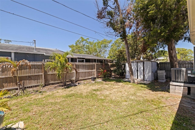 view of yard featuring a storage shed, central AC, a fenced backyard, and an outdoor structure