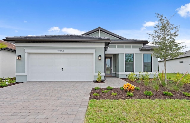17200 Luminous Ave, Venice, FL 34293 - view of front facade with stucco siding, decorative driveway, a garage, and a tile roof