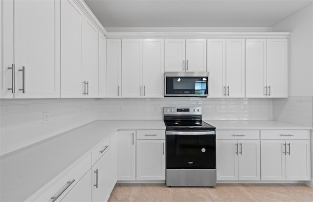 17200 Luminous Ave, Venice, FL 34293 - kitchen featuring stainless steel appliances, light countertops, white cabinets, and tasteful backsplash