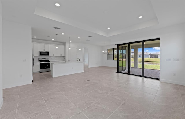 17200 Luminous Ave, Venice, FL 34293 - unfurnished living room with a raised ceiling, baseboards, recessed lighting, light tile patterned floors, and a sink
