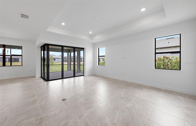 17200 Luminous Ave, Venice, FL 34293 - unfurnished room featuring a raised ceiling, healthy amount of natural light, light tile patterned floors, baseboards, and recessed lighting
