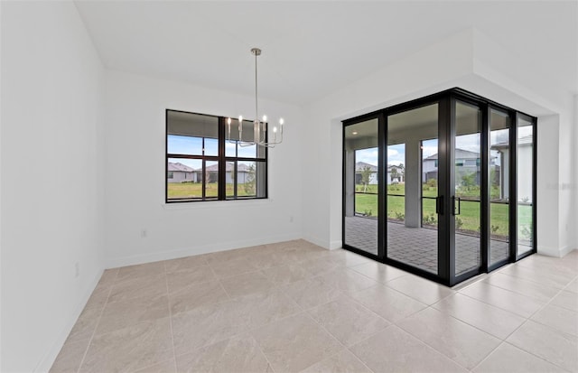 17200 Luminous Ave, Venice, FL 34293 - spare room featuring healthy amount of natural light, a chandelier, light tile patterned floors, and baseboards