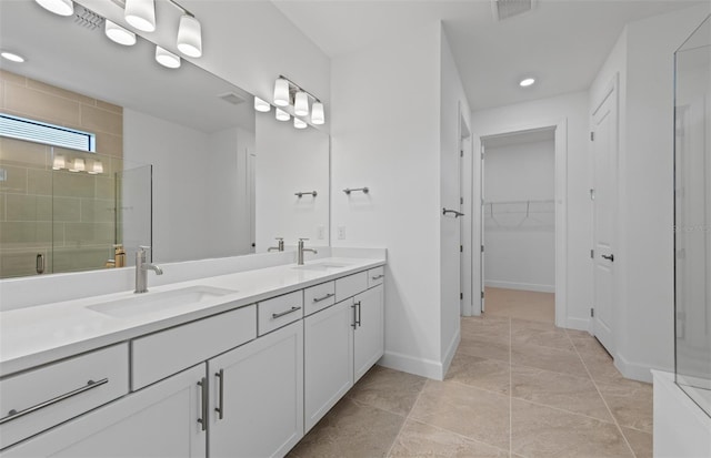 17200 Luminous Ave, Venice, FL 34293 - full bathroom with double vanity, a shower stall, a spacious closet, recessed lighting, and baseboards