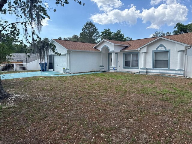 view of front of property with fence, an attached garage, concrete driveway, and stucco siding