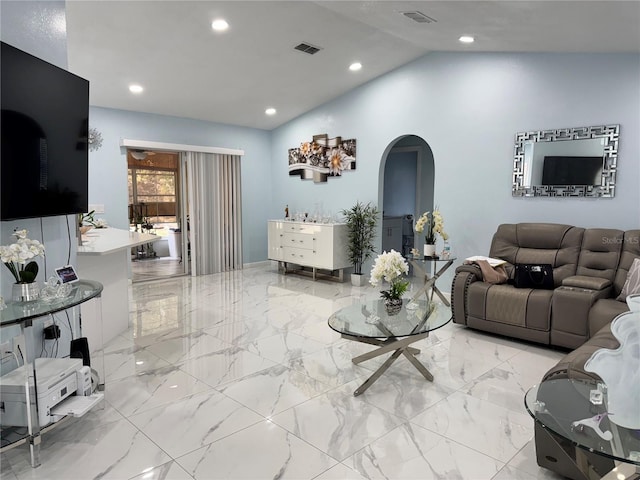 living room featuring arched walkways, lofted ceiling, marble finish floor, and visible vents