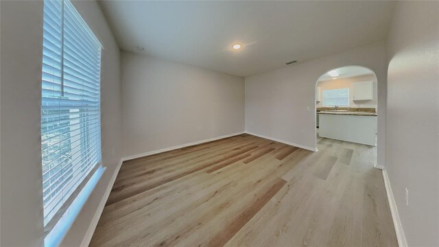 105 Evergreen Dr, Auburndale, FL 33823 - spare room featuring baseboards, light wood-style flooring, visible vents, and arched walkways