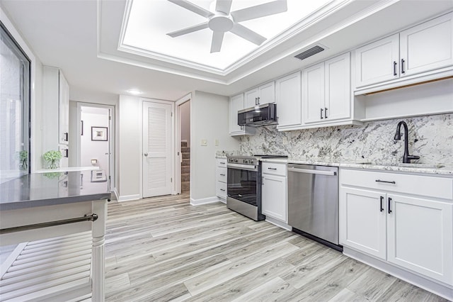 4137 Northmeadow Cir, Tampa, FL 33618 - kitchen featuring a ceiling fan, a sink, light wood-type flooring, stainless steel appliances, and white cabinets