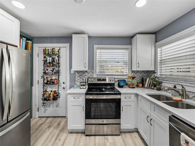 kitchen featuring decorative backsplash, appliances with stainless steel finishes, light countertops, and a sink