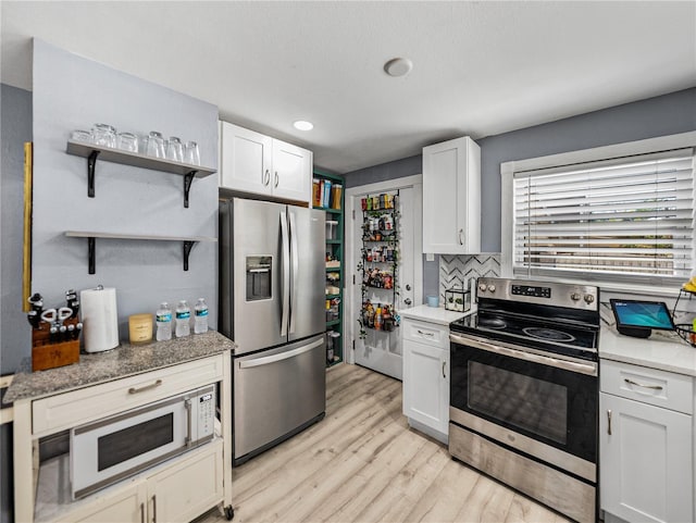 kitchen featuring white cabinets, open shelves, appliances with stainless steel finishes, and light wood finished floors