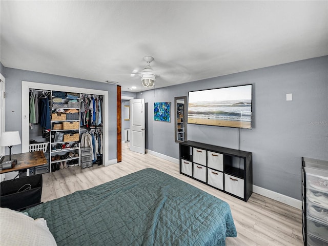 bedroom featuring wood finished floors, a closet, a ceiling fan, and baseboards