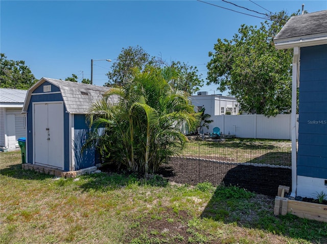 view of yard with a storage unit, fence, and an outdoor structure