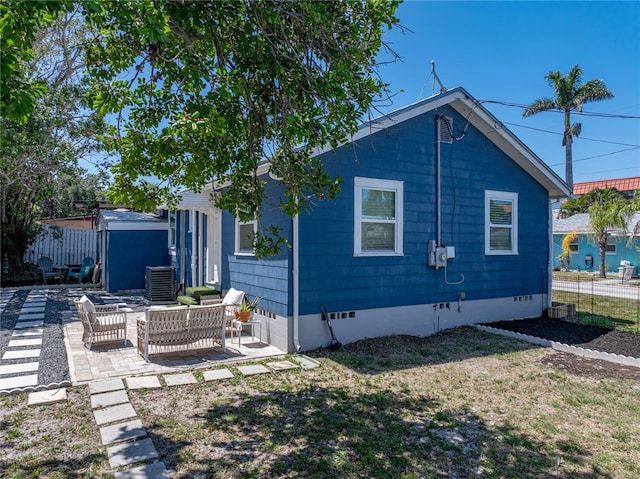 rear view of property featuring a yard, fence, crawl space, a patio area, and central AC