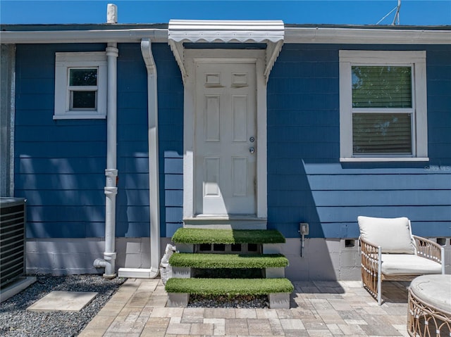 view of exterior entry with central air condition unit and crawl space