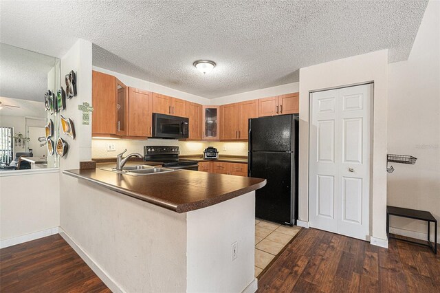 5636 Baywater Dr Unit 5636, Tampa, FL 33615 - kitchen with glass insert cabinets, dark countertops, black appliances, wood finished floors, and a peninsula