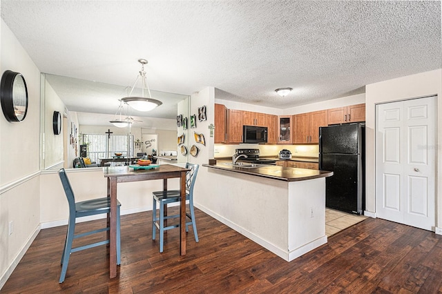 5636 Baywater Dr Unit 5636, Tampa, FL 33615 - kitchen with brown cabinets, glass insert cabinets, dark countertops, dark wood-style floors, and black appliances