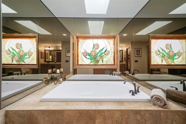 bathroom with a skylight and a bath