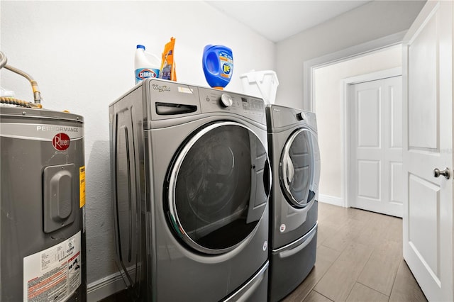 6129 Leeland St S, Saint Petersburg, FL 33715 - clothes washing area with laundry area, wood finished floors, baseboards, separate washer and dryer, and electric water heater
