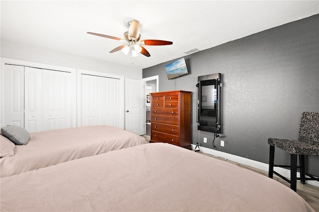 6129 Leeland St S, Saint Petersburg, FL 33715 - bedroom featuring multiple closets, wood finished floors, visible vents, baseboards, and ceiling fan