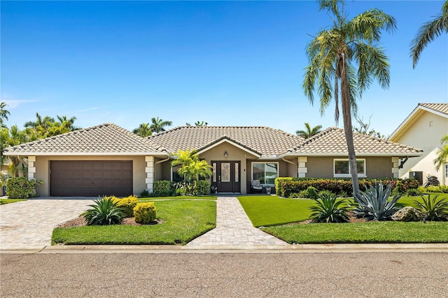 6129 Leeland St S, Saint Petersburg, FL 33715 - ranch-style house featuring a garage, a tiled roof, a front lawn, and stucco siding