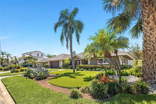 6129 Leeland St S, Saint Petersburg, FL 33715 - view of front of house featuring stucco siding, concrete driveway, a tile roof, a front yard, and a garage