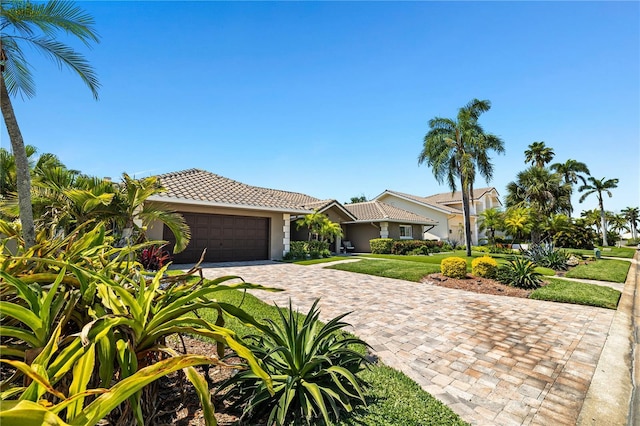 6129 Leeland St S, Saint Petersburg, FL 33715 - view of front of home with decorative driveway, a garage, a tiled roof, a front yard, and stucco siding