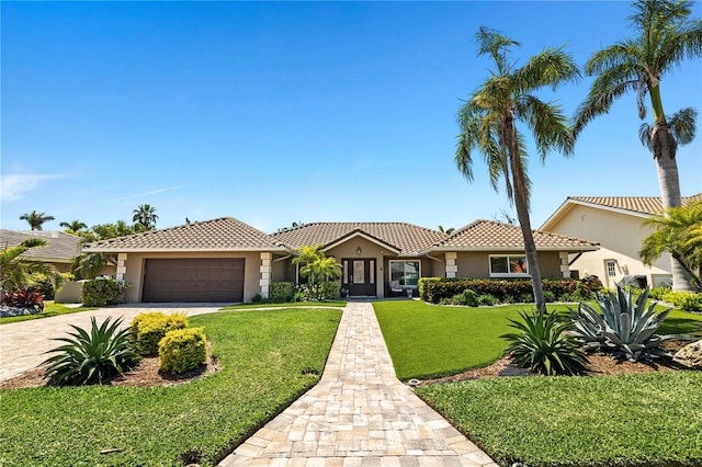 6129 Leeland St S, Saint Petersburg, FL 33715 - view of front of home with stucco siding, a tile roof, driveway, a front yard, and a garage