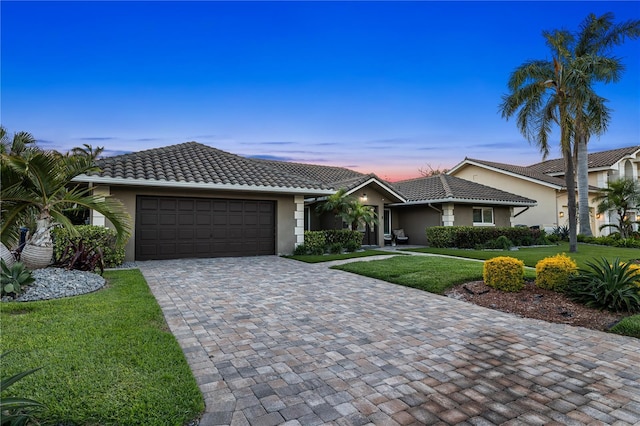6129 Leeland St S, Saint Petersburg, FL 33715 - ranch-style house with stucco siding, an attached garage, a tiled roof, and a lawn