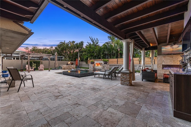 6129 Leeland St S, Saint Petersburg, FL 33715 - view of patio with a fenced backyard, an outdoor stone fireplace, a ceiling fan, and an in ground hot tub