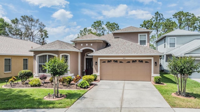 7815 Blue Spring Dr, Land O Lakes, FL 34637 - view of front facade featuring an attached garage, a front lawn, stucco siding, and driveway