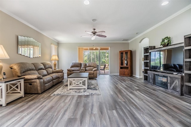 7815 Blue Spring Dr, Land O Lakes, FL 34637 - living room with arched walkways, baseboards, a ceiling fan, wood finished floors, and crown molding