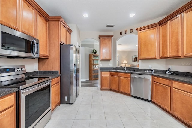 7815 Blue Spring Dr, Land O Lakes, FL 34637 - kitchen with stainless steel appliances, arched walkways, a sink, visible vents, and light tile patterned floors