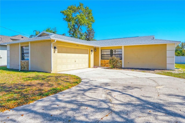 ranch-style house with an attached garage, stucco siding, and driveway