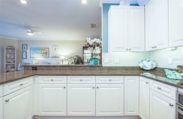 6303 Vista Verde Dr E, Gulfport, FL 33707 - kitchen with visible vents, ornamental molding, decorative backsplash, white cabinets, and a ceiling fan