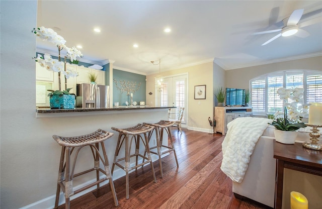 6303 Vista Verde Dr E, Gulfport, FL 33707 - kitchen with stainless steel fridge, dark wood-style flooring, crown molding, and baseboards
